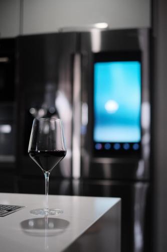 a glass of wine sitting on a table with a television at Stunning exec spa retreat w/panoramic lake views! in Haslett