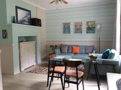 a living room with a couch and a table at Gulls Wing Apartment in Ventnor