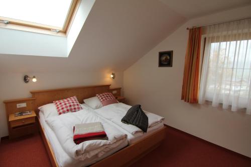 1 dormitorio con cama con almohadas y ventana en Haus Vorrath, en Bad Hofgastein