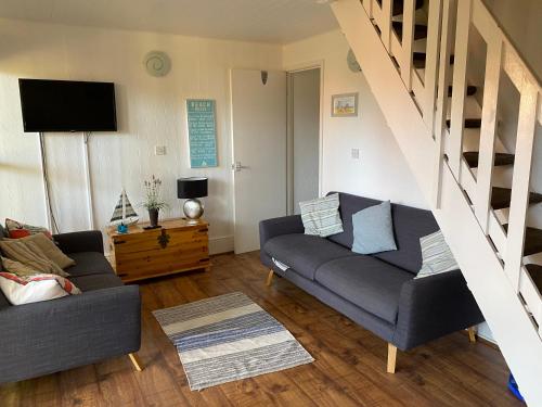 a living room with a couch and a tv at Kingsdown Chalet in Deal