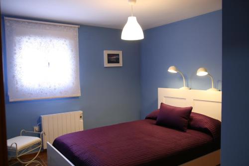 a bedroom with a purple bed in a blue room at Casa Tenerías in Marchagaz