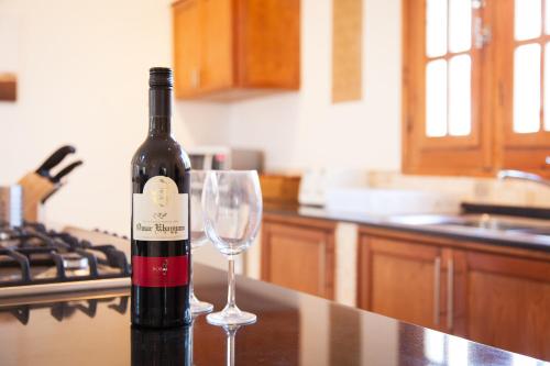 a bottle of wine sitting on a counter with a wine glass at Red Rock Apartments in Dahab