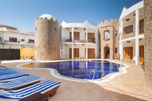 a villa with a swimming pool and two towers at Red Rock Apartments in Dahab