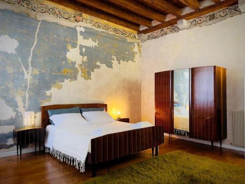 a bedroom with a large bed and a wall mural at Il Palazzetto - La terrazza di Elia in Cividale del Friuli
