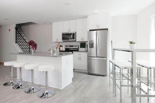 a kitchen with white cabinets and a counter with bar stools at Montgomery condo in Philadelphia