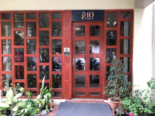 uma porta vermelha de um edifício com plantas em The G Ten Holiday Inn em Hulhumale