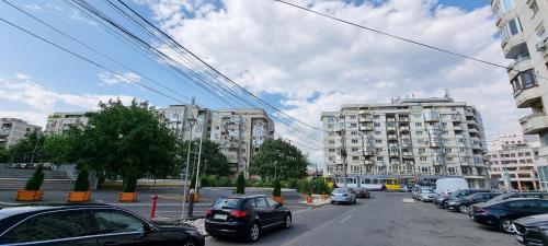a street with cars parked in a city with buildings at Central Residence in Ploieşti
