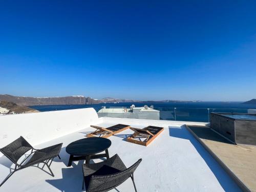 a view from the roof of a house with chairs and tables at ArmonOia Suites in Oia