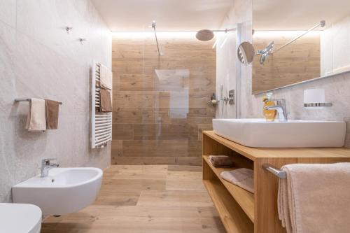 a bathroom with a white sink and a shower at Ciasa Nene Franzl in Badia
