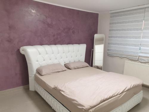 białe łóżko w pokoju z fioletową ścianą w obiekcie Sehr grosse 5 Zimmer Wohnung mit Garten und terasse w mieście Wiesbaden