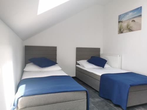 two beds in a room with blue and white at Domki Black Pearl Mielno basen sauna jacuzzi in Mielno