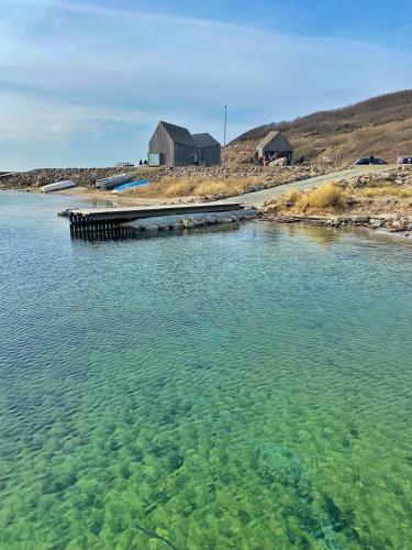 a large body of water with a house in the background at Hyggehytten auf Bornholm in Østermarie
