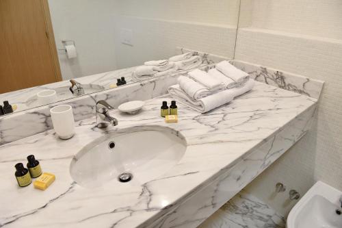 a bathroom with a sink and a white marble counter top at Casa Maria Vera - Deluxe Marina Apartment with Pool in Lagos