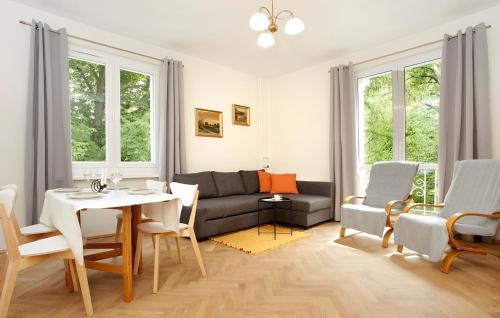 a living room with a couch and a table and chairs at Apartament Ada in Sopot