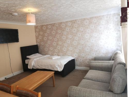 a hotel room with a bed and a couch and a table at Spacious Entire Flat,1D in Great Yarmouth