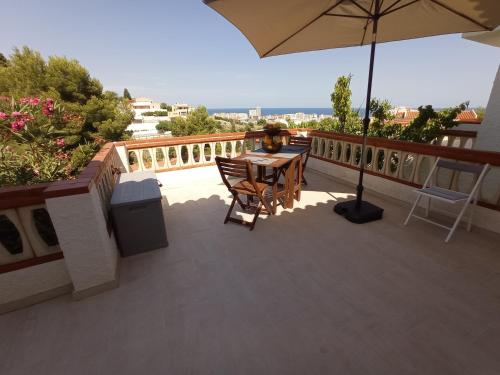d'une terrasse avec une table et un parasol sur le balcon. dans l'établissement Charmant appartement avec vue sur le château de Peniscola, à Peñíscola