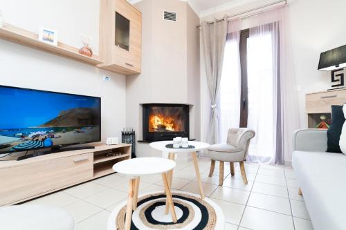 a living room with a tv and a fireplace at Παραθαλάσσια κατοικία με μπάρμπεκιου και τζακούζι in Stavros