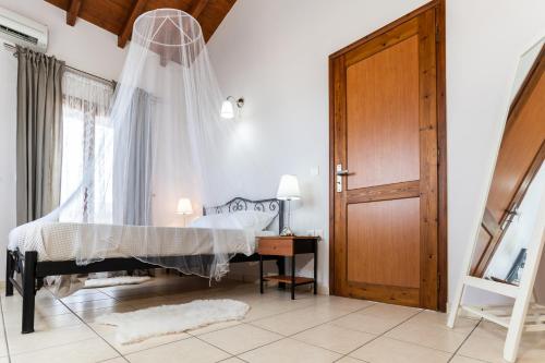 a bedroom with a bed with a mosquito net at Παραθαλάσσια κατοικία με μπάρμπεκιου και τζακούζι in Stavros