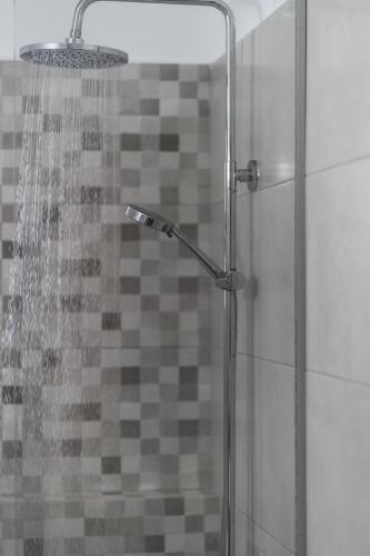 a shower with a glass door with a shower head at Παραθαλάσσια κατοικία με μπάρμπεκιου και τζακούζι in Stavros