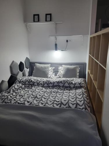 a bedroom with a bed with a black and white comforter at KLIF 3 Mini-Apartament in Warka