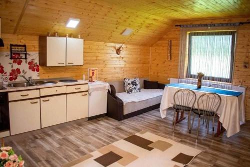 a kitchen with a table and a couch in a room at Cabana Ancuța in Vartop