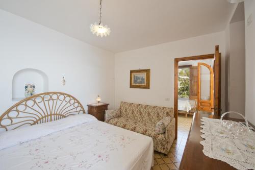 a bedroom with a bed and a couch at Gabbiano in Praiano