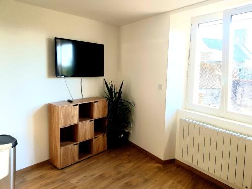 a living room with a flat screen tv on a wall at Appartement dans le bourg du Guildo - Saint-Cast in Saint-Cast-le-Guildo