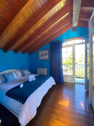 1 dormitorio con 1 cama grande y paredes azules en María Bonita Chalet Villa independiente con piscina y amplio jardín, en Cabezón de la Sal