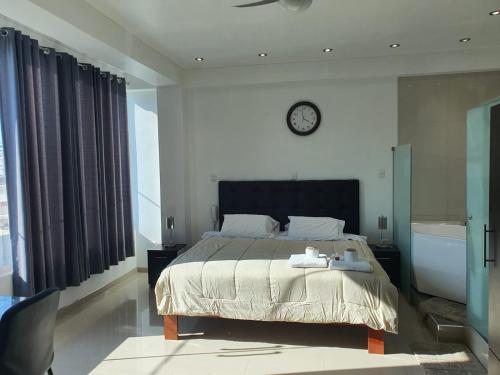 a bedroom with a bed and a clock on the wall at GOLDEN SKY in Talara
