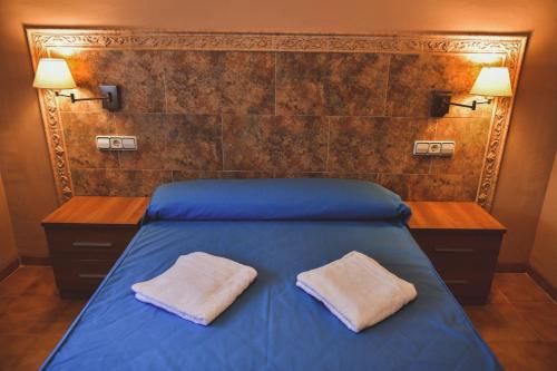 1 dormitorio con 1 cama azul y 2 almohadas en TEPINSA · Alquiler de Apartamentos, en Torreblanca