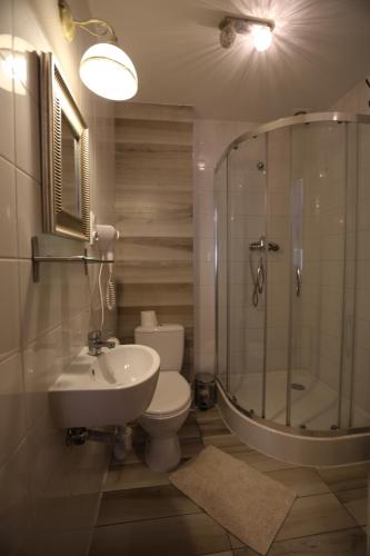a bathroom with a shower, toilet and sink at Deja Vu Hostel in Warsaw