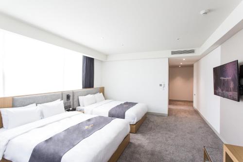 two beds in a hotel room at Interburgo Hotel Wonju in Wonju