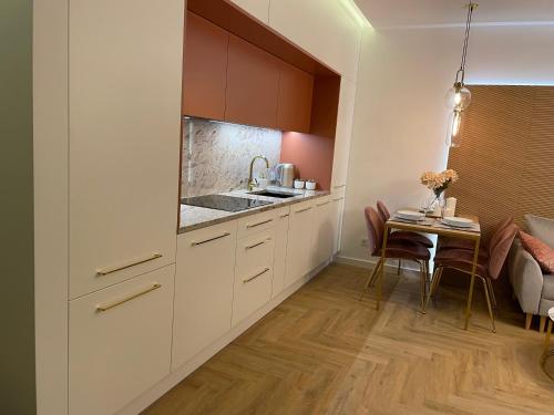 a kitchen with white cabinets and a small table at CRYSTAL CAVE Apartment in Wieliczka