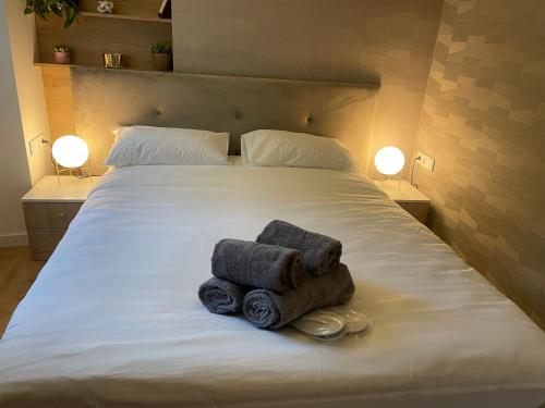 dos toallas sentadas en una cama con dos lámparas en CRYSTAL CAVE Apartment, en Wieliczka