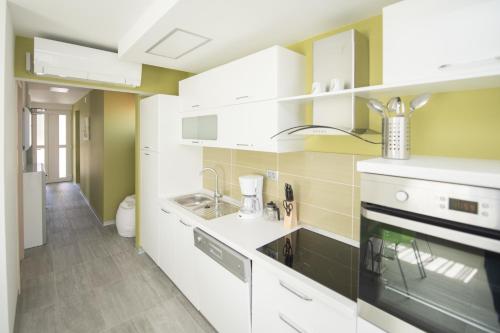 a kitchen with white cabinets and a sink at Villa Danex Premium in Umag