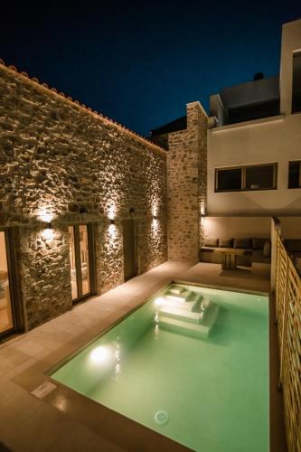 a villa with a swimming pool at night at Mani Luxury Suites and Studios in Gytheio with Private Pools in Gythio
