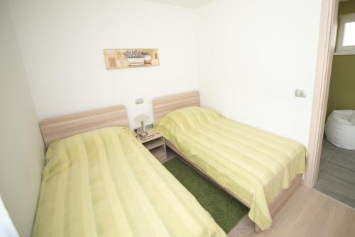 two beds in a small room with yellow sheets at Villa Danex Premium in Umag