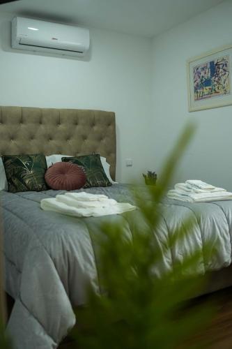 a bedroom with a bed with a green comforter at Casa de Campo Gracinda in Tourém