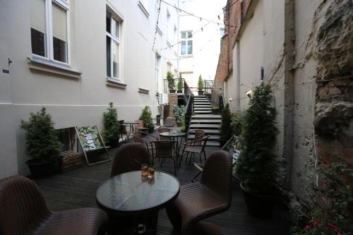 eine Außenterrasse mit Tischen, Stühlen und Treppen in der Unterkunft Deja Vu Hostel in Warschau