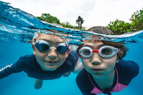 two young women wearing goggles swimming in the water at Alpine-Pacific Holiday Park in Kaikoura