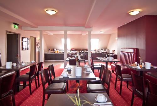 comedor con mesas y sillas y cocina en Hotel Savoy, en Hamburgo