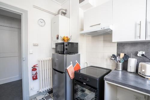 a kitchen with a stainless steel refrigerator and a stove at SUPERLOGIS L'Alysse Classé 3étoiles HYPERCENTRE BLOIS in Blois