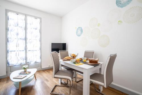 a dining room with a white table and chairs at SUPERLOGIS L'Alysse Classé 3étoiles HYPERCENTRE BLOIS in Blois