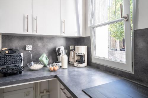 a kitchen counter with a coffee maker and a window at SUPERLOGIS L'Alysse Classé 3étoiles HYPERCENTRE BLOIS in Blois
