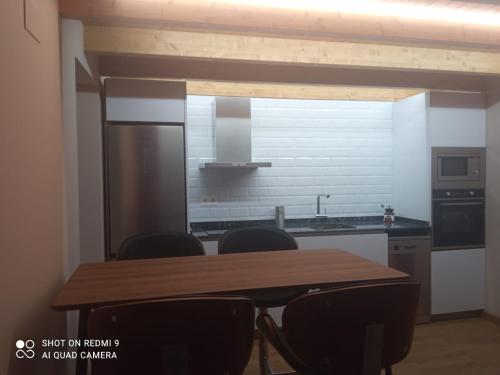 a kitchen with a wooden table and chairs at La Casina de Tano (Playa Tauran) in Luarca
