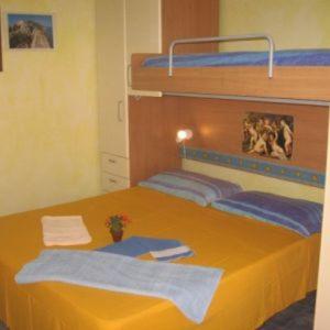 a bedroom with a bunk bed with towels on it at Il Gabbiano Blu - Monolocale Giallo in Marettimo