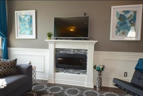 a living room with a tv on top of a fireplace at The SoMa Furnished Residences in Hamilton