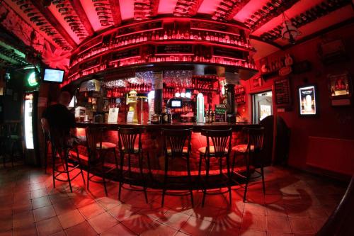 a bar with red chairs in a red room at Apartamenty Smętek in Ełk