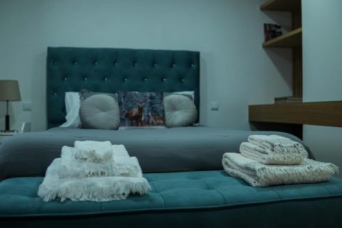 a bedroom with a bed with a blue couch with pillows at Casa de Campo Gracinda in Tourém