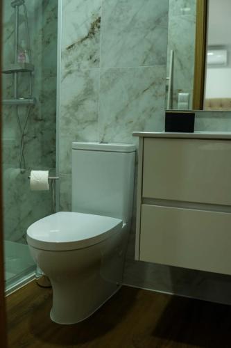 a bathroom with a white toilet and a mirror at Casa de Campo Gracinda in Tourém